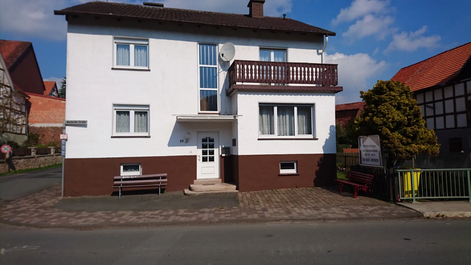 Außenansicht des Ferienhauses – weißes Haus mit Balkon an der Dorfstraße