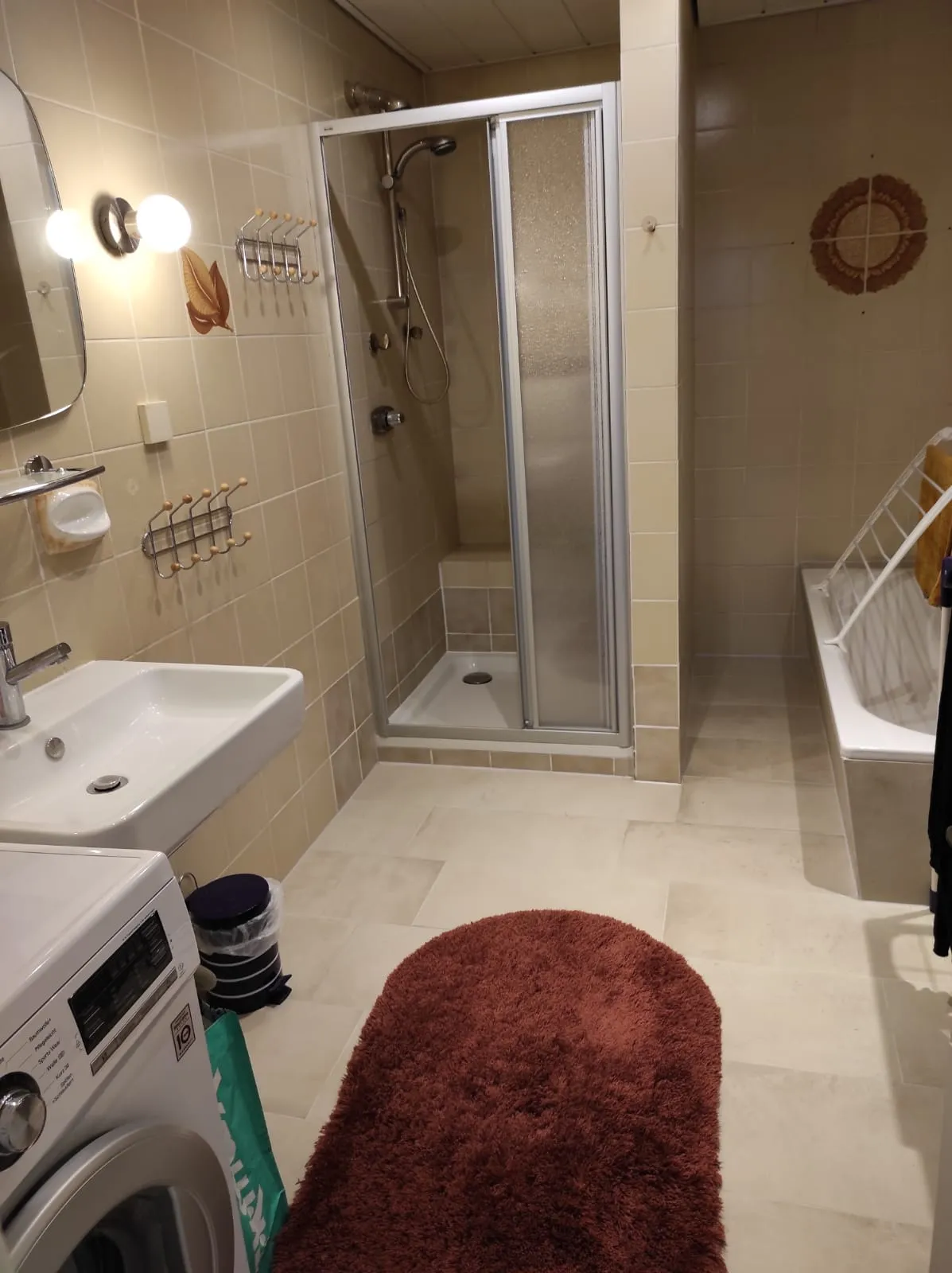Badezimmer mit Dusche, Badewanne und Waschmaschine