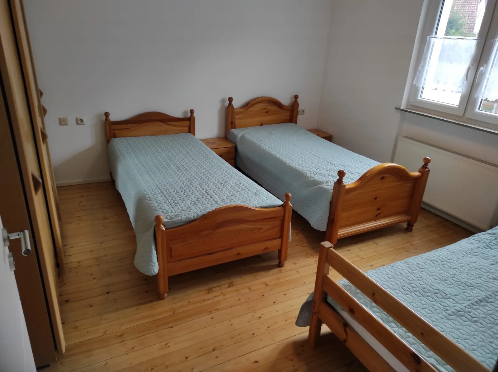Schlafzimmer mit drei massiven Einzelbetten aus Kiefernholz