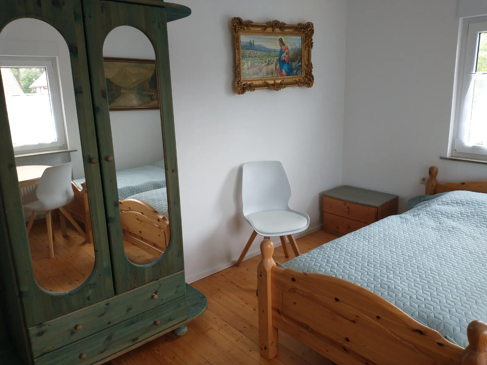 Schlafzimmer mit Doppelbett und antikem Kleiderschrank